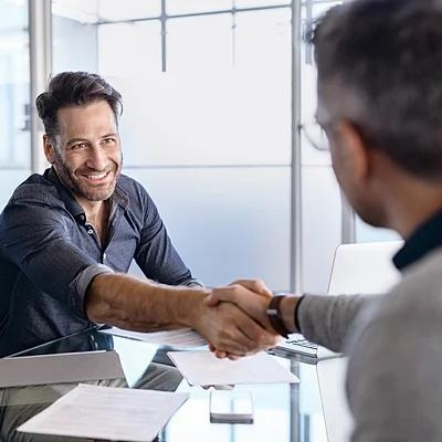 Ein Mann schüttelt seinem Finanzierungsberater die Hand.