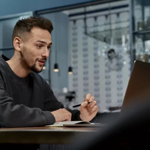 Ein Mann sitzt am Laptop und erkundigt sich zum Thema Baufinanzierung.
